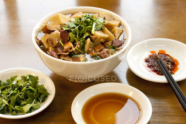 Comida tradicional china, sopa de haslet servida con psarsley y salsa de soja en platos - foto de stock