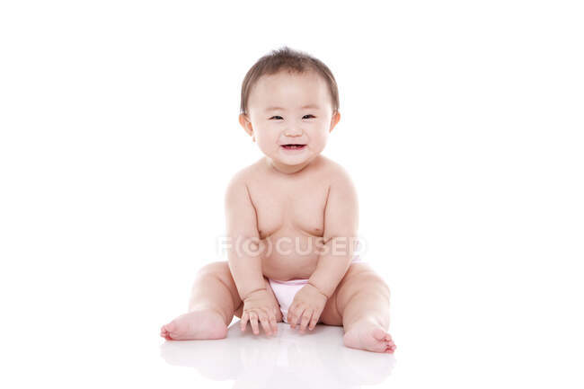 Studio shot of cute Chinese baby sitting on floor — Stock Photo