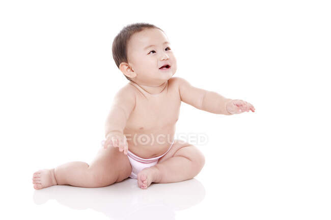 Студийный снимок симпатичного китайского ребенка, сидящего на полу — стоковое фото