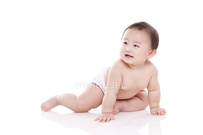 Студийный снимок симпатичного китайского ребенка, сидящего на полу — стоковое фото