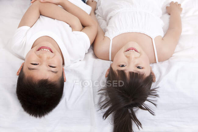 Милые китайские дети лежат в постели — стоковое фото