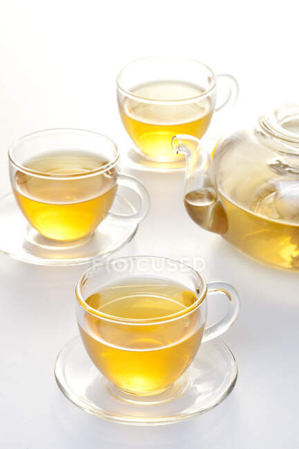 Скляний чайний набір з горщиком і чаєм в чашках ізольовані на білому фоні — стокове фото
