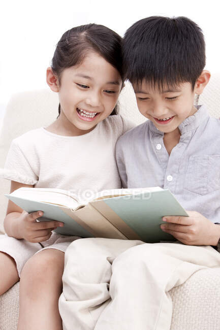 Piccolo ragazzo e ragazza cinese che legge un libro — Foto stock