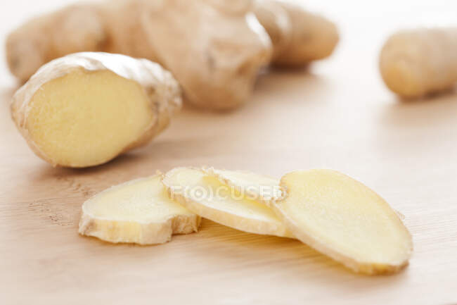 Sliced Ginger on wooden cutting board surface — Stock Photo