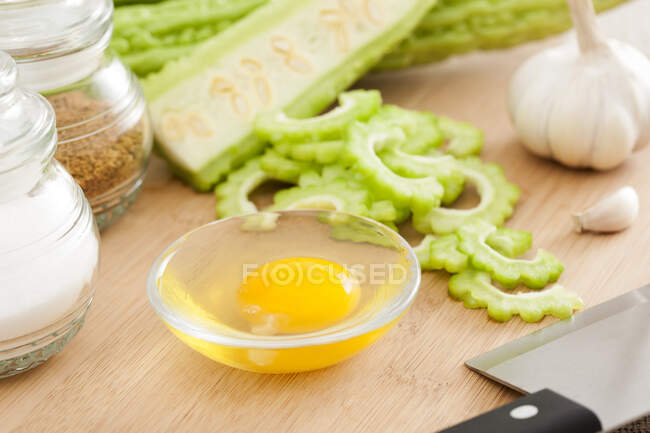 Chopped bitter melon with egg and spices on wooden board — Stock Photo
