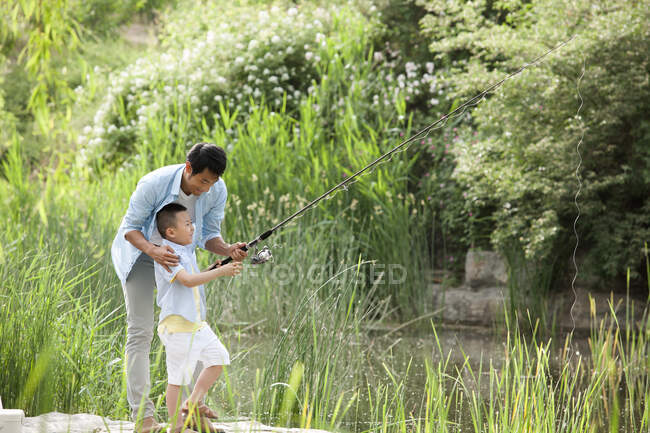 Glücklicher Vater und Sohn beim Angeln im Park — Stockfoto