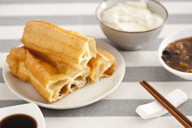 Comida china, youtiao y jalea de tofu servidos en el plato - foto de stock