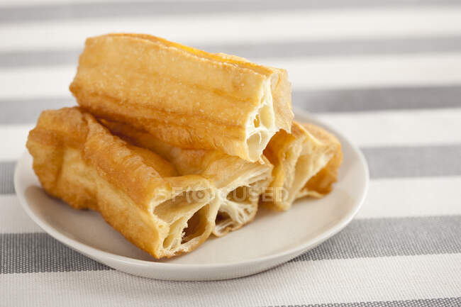 Oily youtiao pastries served on plate — Stock Photo