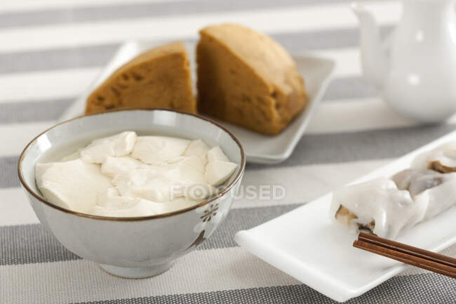 Jalea de soja con comida y palillos servidos en la mesa - foto de stock