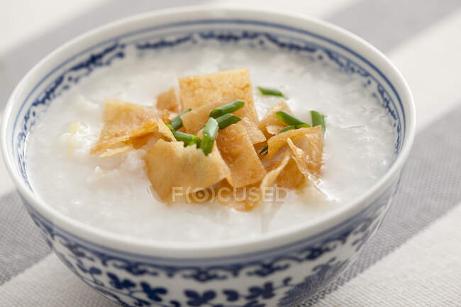 Chinese rice porridge with crisps and green onion — Stock Photo