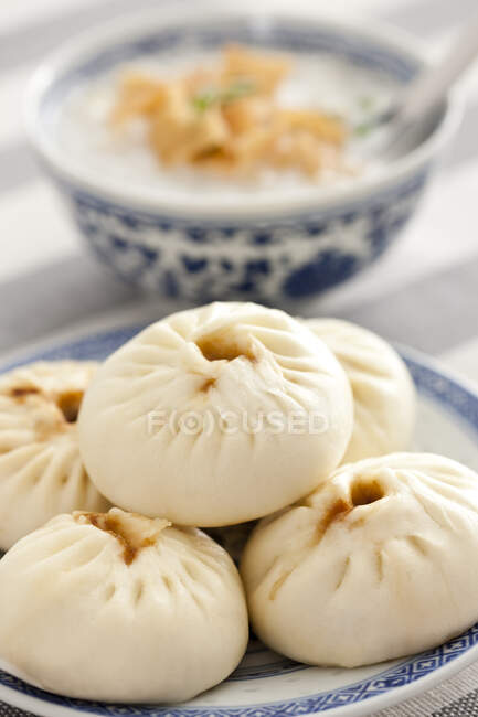 Chinese food, rice porridge and steamed buns served on plate — Stock Photo