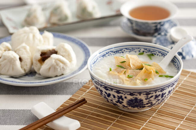 Traditional Chinese breakfast, rice porridge with crisps in bowl — Stock Photo