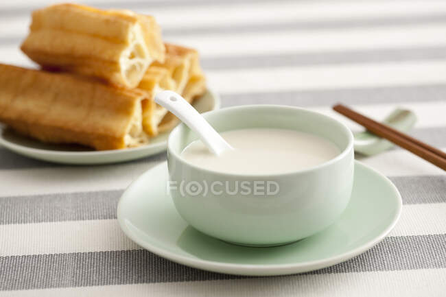 Lait de soja avec nourriture et baguettes servis sur la table — Photo de stock