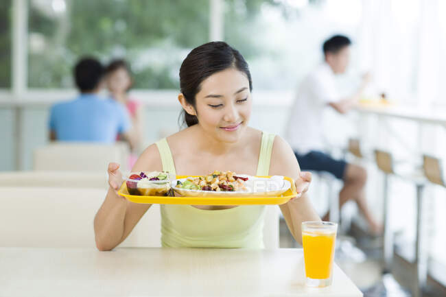 Young Chinese woman having a meal in restaurant — Stock Photo