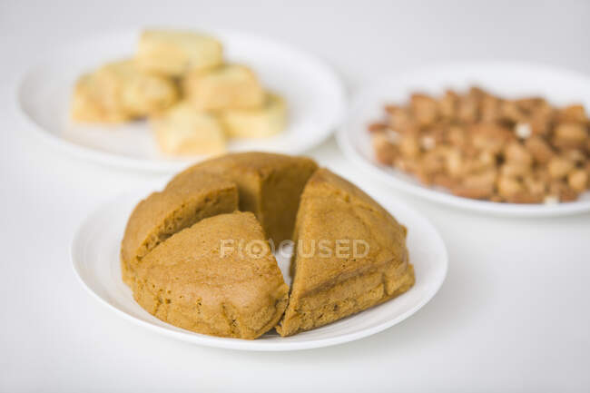 Delicious pastries in white plates on white background — Stock Photo