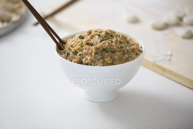 Stuffing for dumplings in bowl with chopsticks — Stock Photo