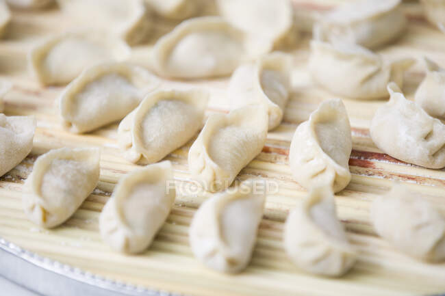 Linhas de Dumplings na superfície de madeira, tiro de perto — Fotografia de Stock