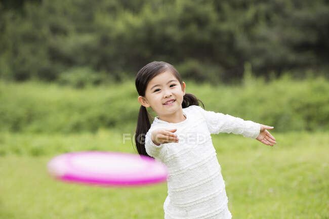 Счастливый китайский мальчик играет во фрисби — стоковое фото