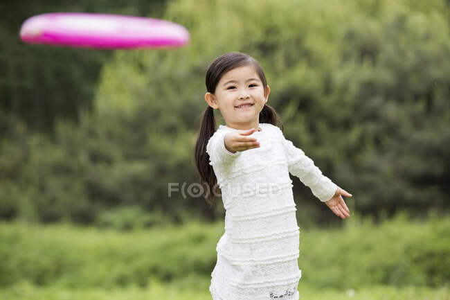 Menino chinês feliz jogando frisbee — Fotografia de Stock
