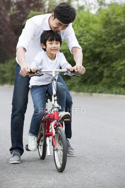 Padre cinese che insegna al figlio ad andare in bicicletta — Foto stock