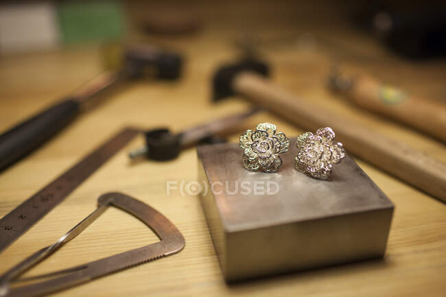 A pair of earrings on jeweler's workbench — Stock Photo