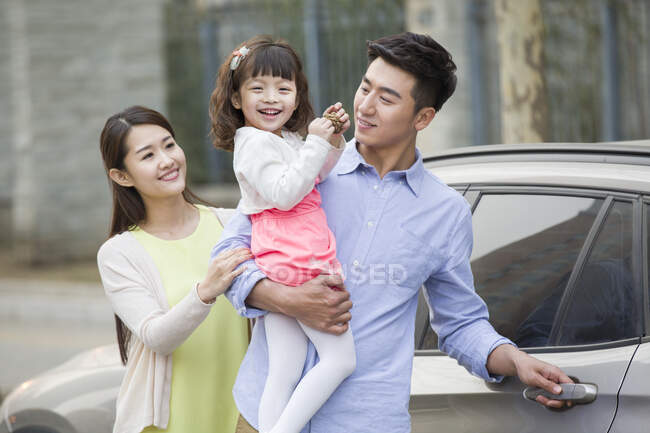 Счастливая молодая китайская семья и автомобиль — стоковое фото