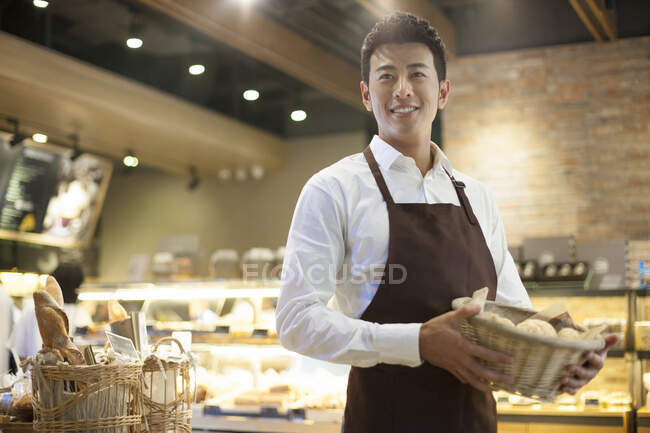 Young Chinese man working in bakery — Stock Photo