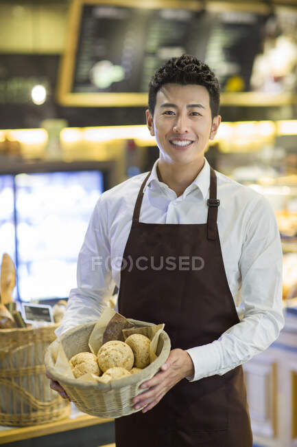 Jeune Chinois travaillant dans la boulangerie — Photo de stock