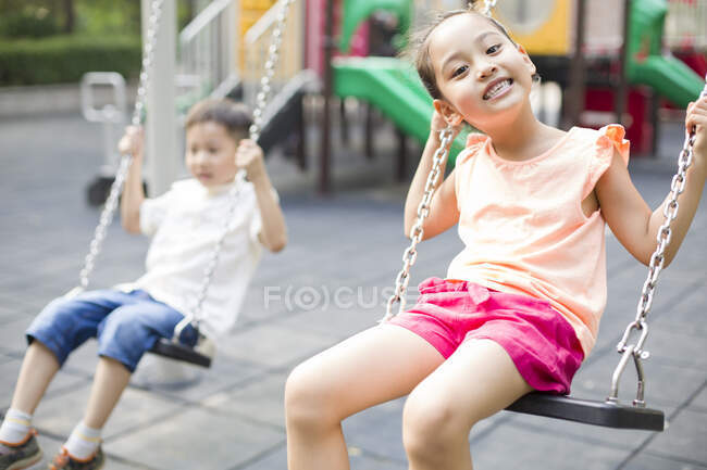 Счастливая китайская девочка на качелях — стоковое фото