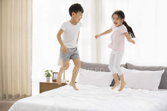 Happy Chinese sibling having fun in bedroom — Stock Photo