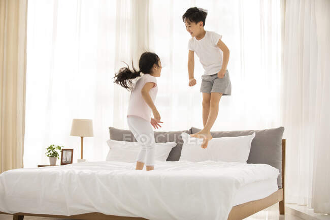 Happy Chinese sibling having fun in bedroom — Stock Photo
