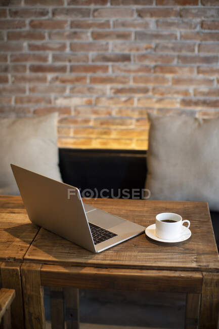 Café y portátil en la mesa - foto de stock