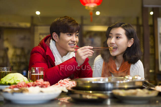 Молодая китайская пара ужинает в ресторане с горячим баром — стоковое фото
