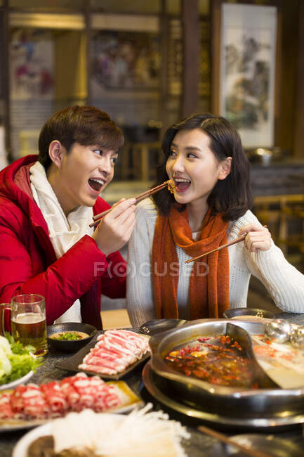 Молодая китайская пара ужинает в ресторане с горячим баром — стоковое фото
