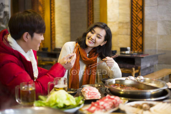 Joven pareja china cenando en el restaurante hotpot - foto de stock