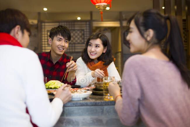 Молодые китайские друзья ужинают в ресторане с горячим баром — стоковое фото