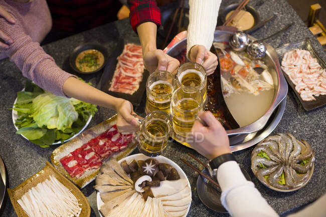 Jeunes amis chinois buvant de la bière au restaurant hotpot — Photo de stock