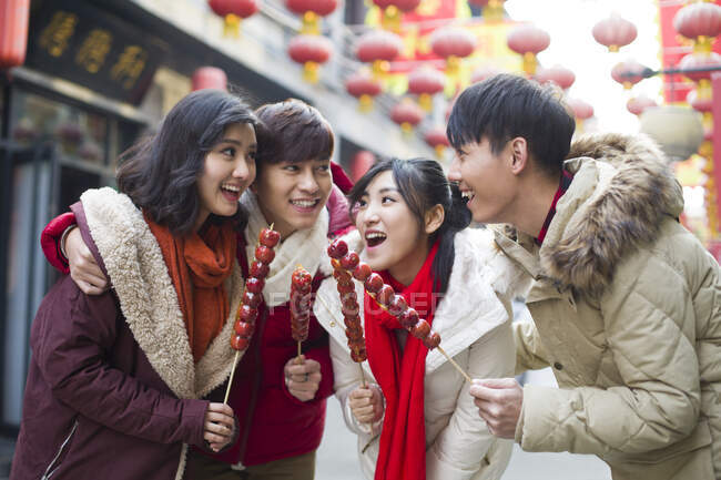 Junge chinesische Freunde mit kandierten Haw-Beeren feiern chinesisches Neujahr — Stockfoto