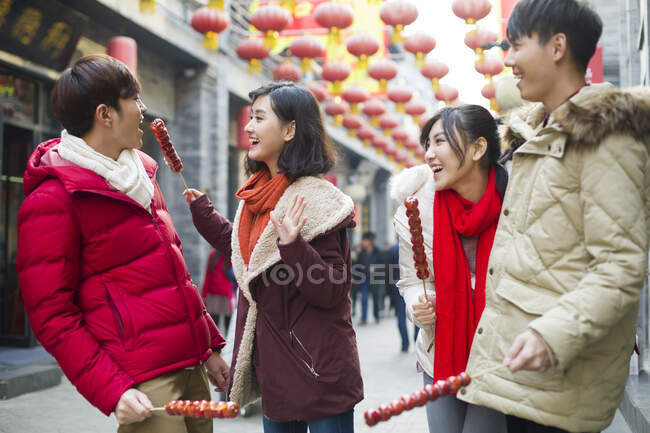 Jovens amigos chineses com bagas de haw cristalizadas celebrando o Ano Novo Chinês — Fotografia de Stock