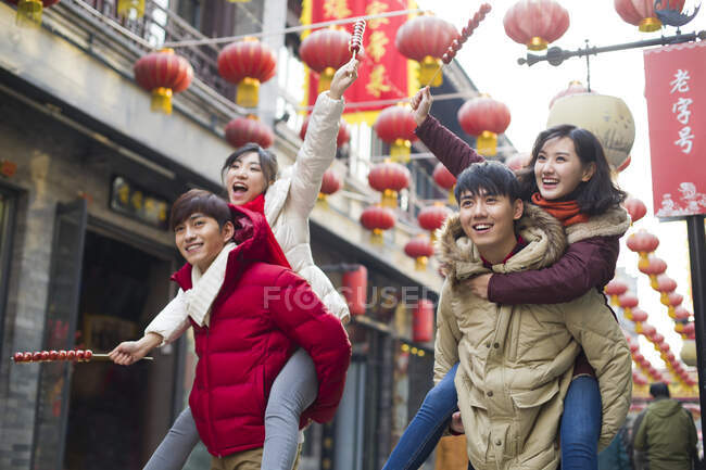 Jovens amigos chineses com bagas de haw cristalizadas celebrando o Ano Novo Chinês — Fotografia de Stock