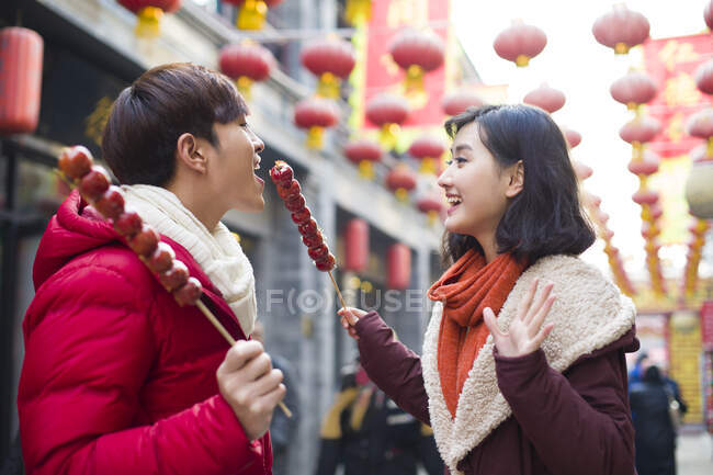 Jeune couple chinois avec des baies confites célébrant le Nouvel An chinois — Photo de stock