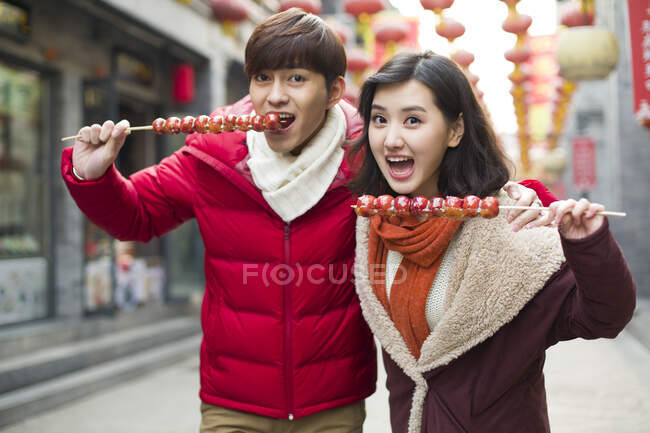 Jeune couple chinois avec des baies confites célébrant le Nouvel An chinois — Photo de stock
