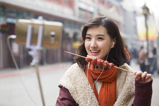 Jovem chinesa tomando auto retrato com um telefone inteligente — Fotografia de Stock