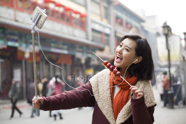 Jovem chinesa tomando auto retrato com um telefone inteligente — Fotografia de Stock
