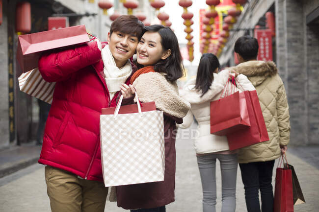 Счастливая молодая китайская пара делает покупки к китайскому Новому году — стоковое фото