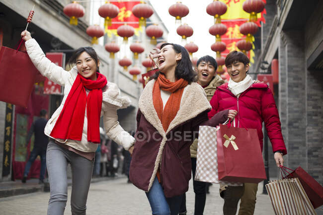 Jovens amigos chineses felizes comprando Ano Novo Chinês — Fotografia de Stock