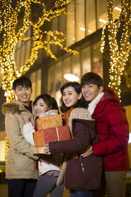 Jovens amigos chineses felizes com presentes de ano novo — Fotografia de Stock