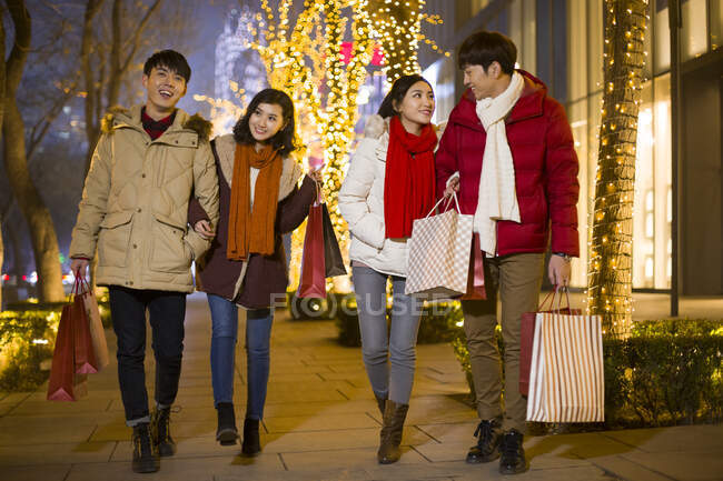 Happy young Chinese friends shopping for Chinese New Year — Stock Photo