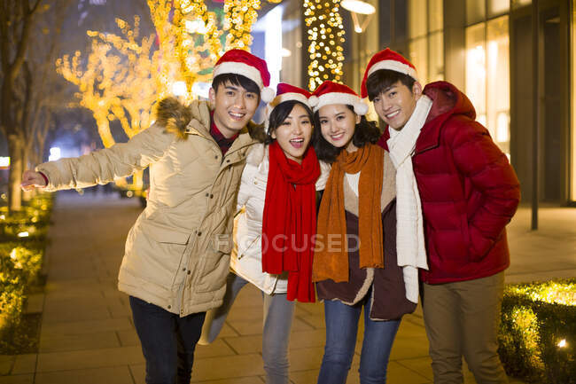 Heureux jeunes amis chinois célébrant Noël — Photo de stock