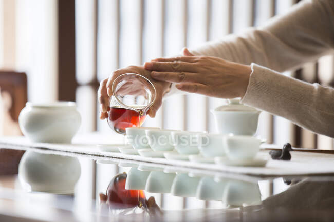 Cropped shot of woman performing tea ceremony, pouring tea — Stock Photo